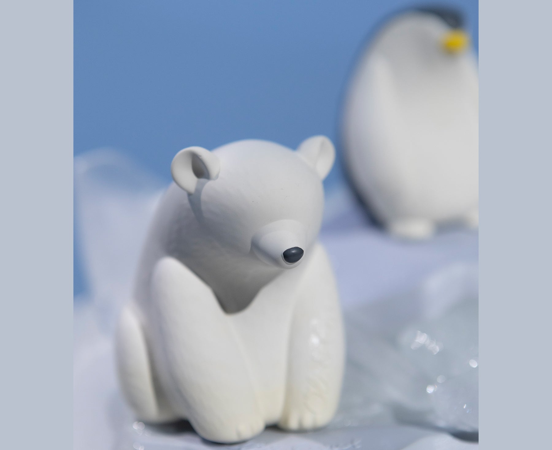 White polar bear chewable toy on a blue base of ice with Oli & Carol branding.
