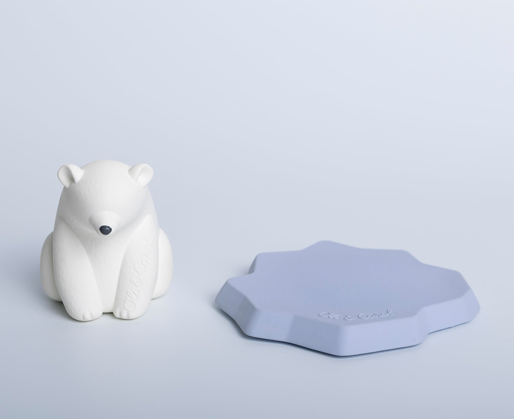 White polar bear chewable toy on a blue base of ice with Oli & Carol branding.